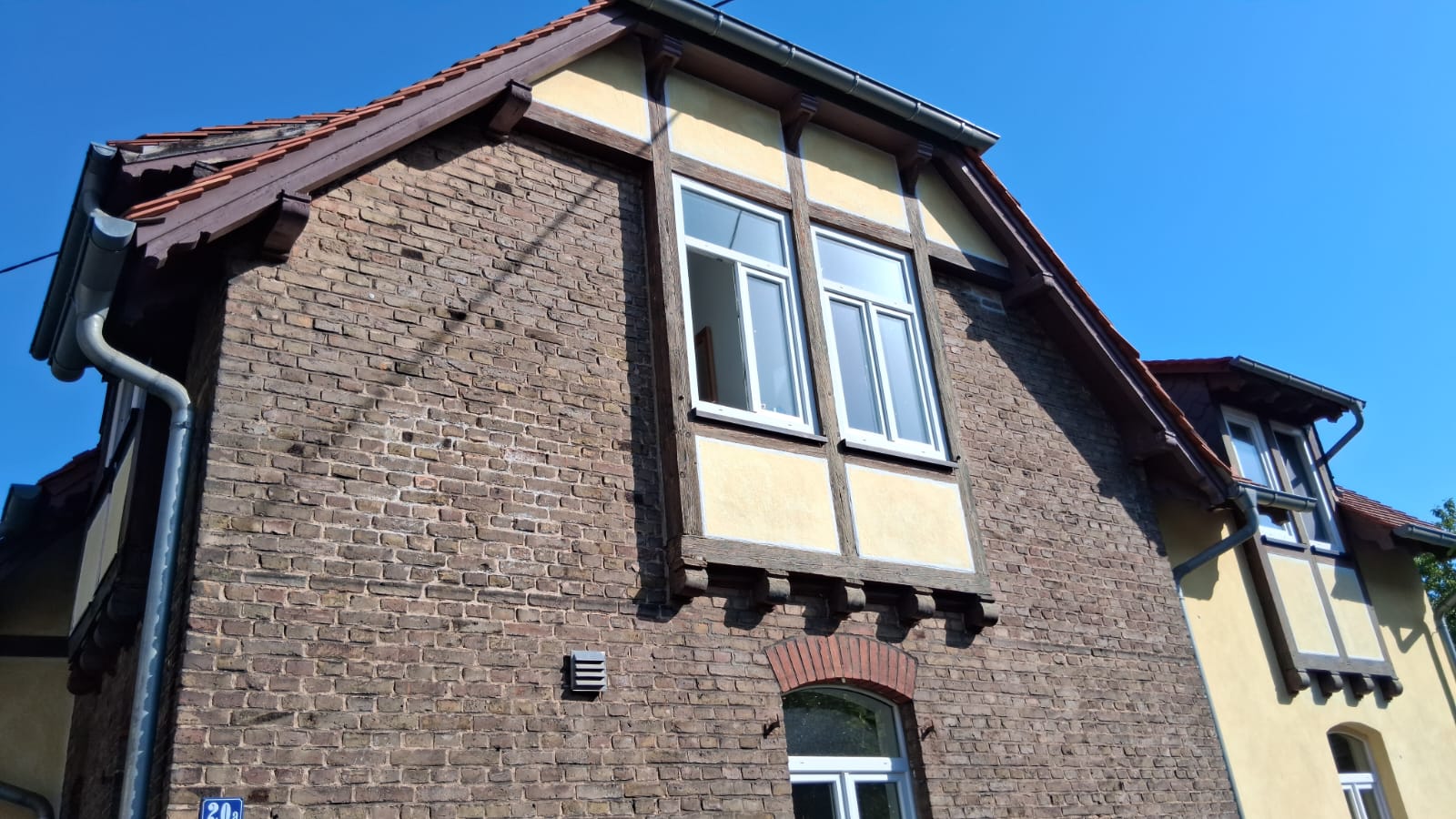 Denkmalgeschützte Fassade in Frankfurt am Main, Fachwerk-Giebel mit Backsteinsockel vor der Sanierung – ACG Bausanierung GmbH